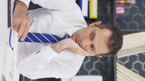 Vertical-video-of-Businessman-shrinking-and-depressed-at-work.